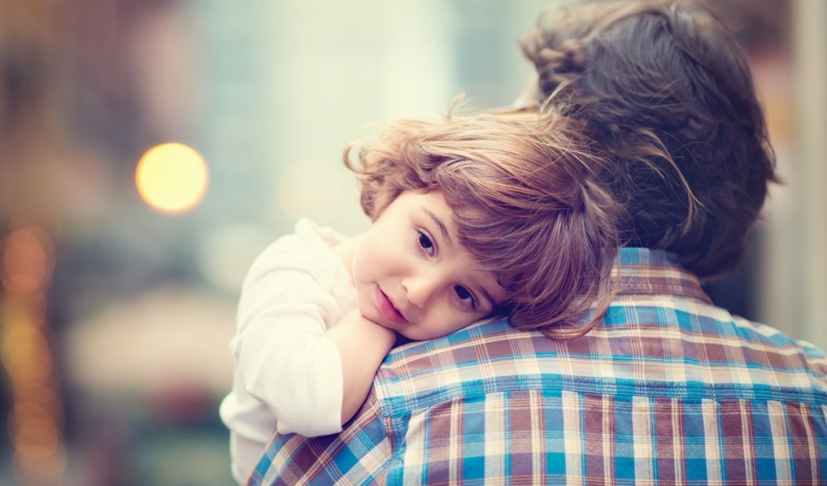 Little girl being held by her father